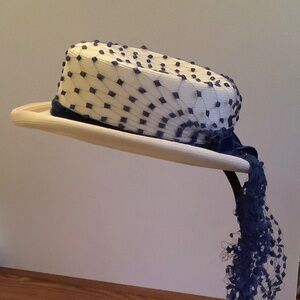 White straw like derby hat with navy lace trip